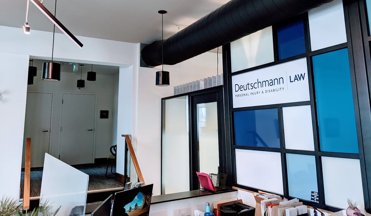 The reception area of the firm's Kitchener office, with the Deutschmann Law sign above the front desk