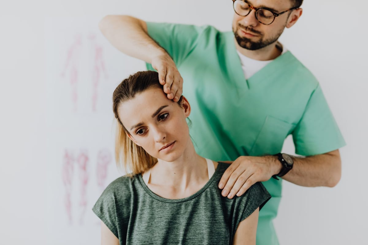 A clinician examining a patient's neck during an injury assessment
