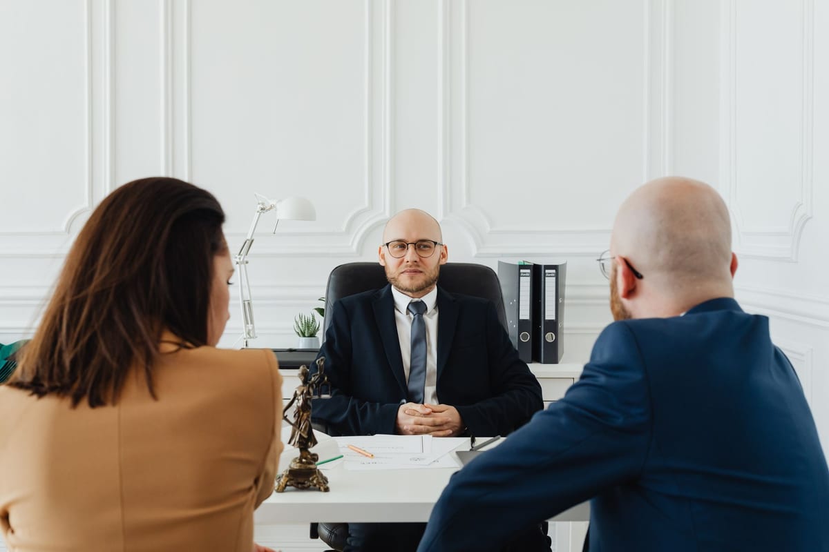 A lawyer walking two clients through paperwork at a desk